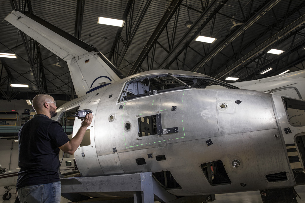 Portable photogrammetry camera system taking measurements on the cockpit and fuselage of a commercial airplane for quality control purposes