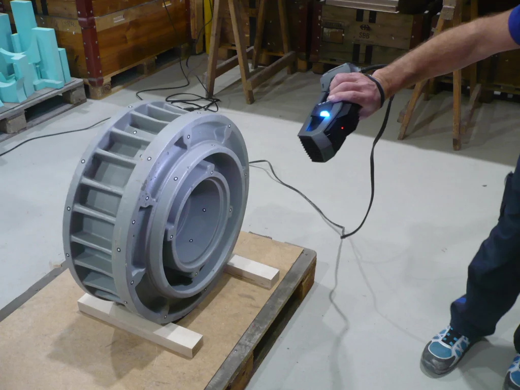 Employee using the Go!SCAN SPARK to scan a round casted part on a wood pallet