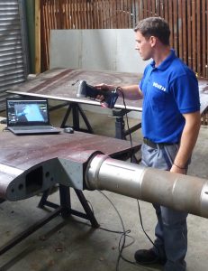 Voith employee in blue shirt using HandySCAN 3D SILVER to scan a large guide vane