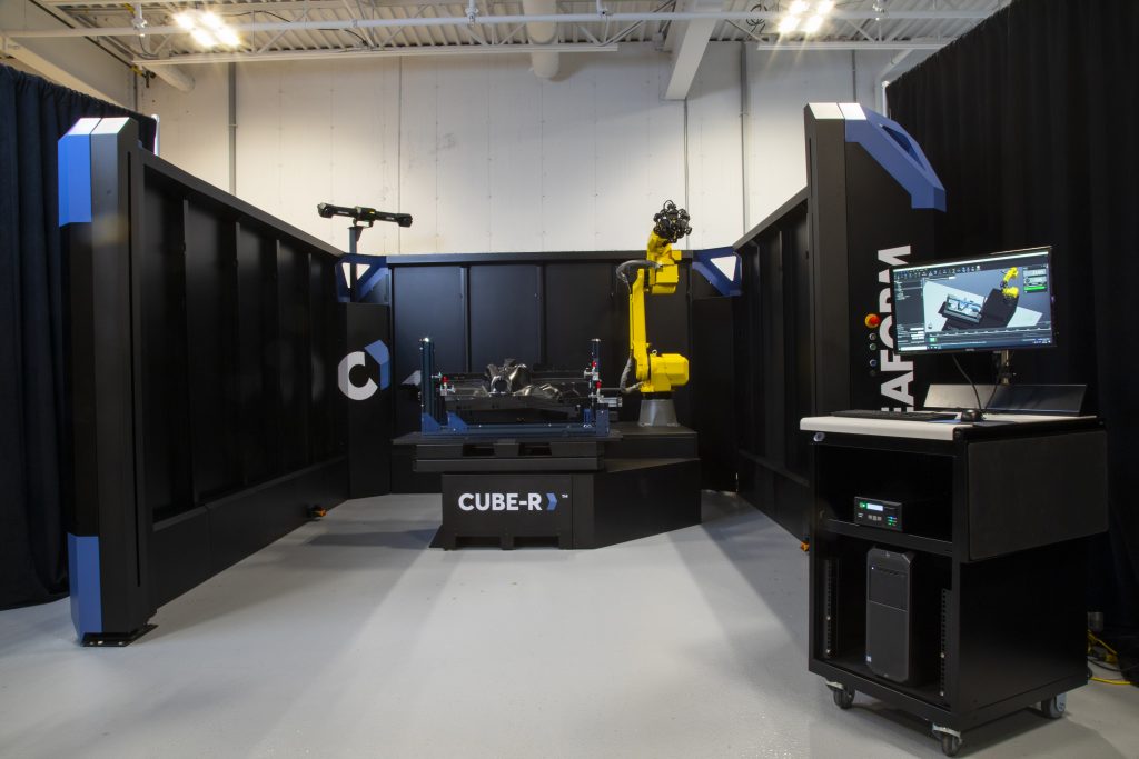 Cube-R que contiene un guardabarros medido por un MetraSCAN 3D-R frente a una estación de trabajo que muestra VXinspect
