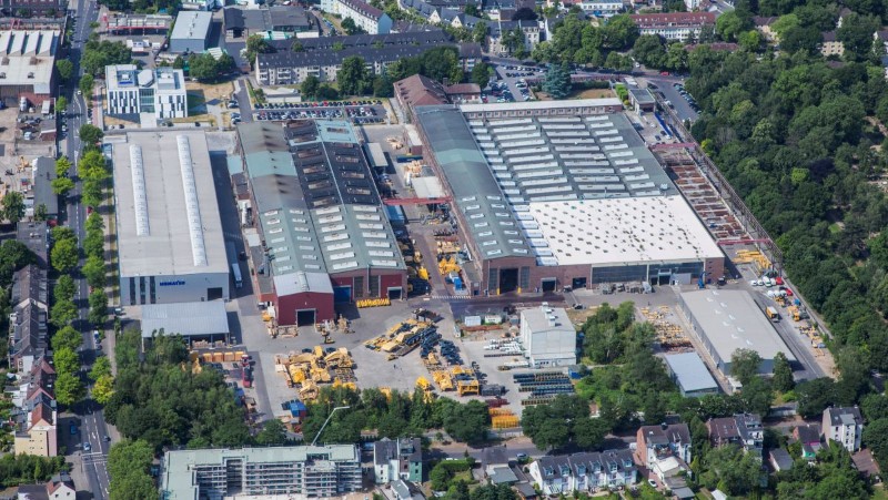 View from above of the Komatsu plant in Düsseldorf. The company premises with warehouses can be seen. Materials are stored in front of the warehouses.